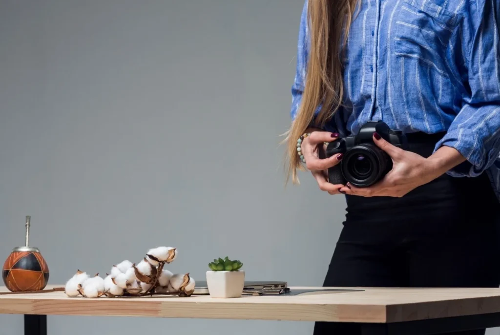 woman holding a camera in what appears to be a studio