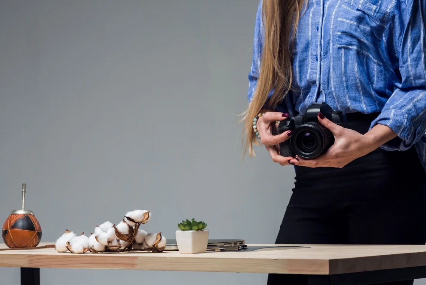 woman holding a camera in what appears to be a studio